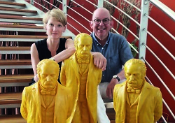 Auf dem Bild sind Anne-Dore Krohn und Denis Scheck mit goldenen Statuen im Vordergrund zu sehen.