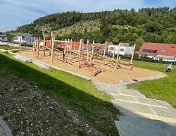 Auf dem Bild sind Spielgeräte zum Klettern und Balancieren auf dem Spielplatz an der Kocherburgschule zu sehen.
