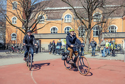 Auf dem Bild sind Oberbürgermeister Frederick Brütting (re.) und Erster Bürgermeister Wolfgang Steidle auf Fahrrädern vor der Mobilitätsstation an der Bohlschule zu sehen.