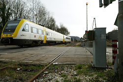Das Bild zeigt den Bahnübergang in der Walkstraße und einen Zug, der darüber fährt.