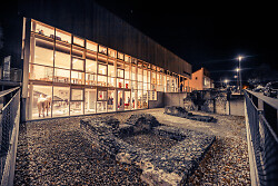 Auf dem Bild ist die Außenfassade des Limesmuseums bei Nacht zu sehen.