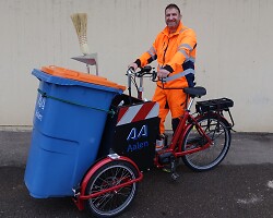 Auf dem Bild ist der Bauhof-Mitarbeiter Peter Preuß auf dem Cargo-Bike zu sehen.