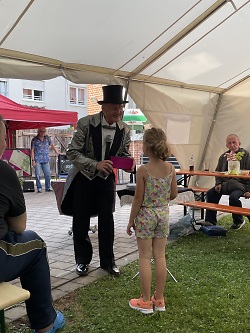 Ein Zauberkünstler zeigt einem kleinen Mädchen seine Tricks