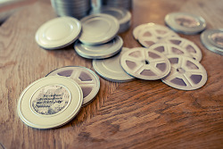DVDs, die wie Filmdosen aussehen liegen auf einem Holztisch