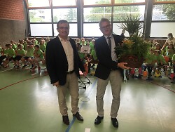 Auf diesem Bild ist Aalens Erster Bürgermeister Wolfgang Steidle zu sehen, der dem scheidenden Rektor der Grauleshofschule, Dr. Wolfgang Becker, einen Geschenkkorb überreicht.