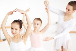 Auf dem Bild sind Ballett tanzende Mädchen in weißen Kostümen zu sehen.
