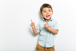 Auf dem Bild ist ein kleiner Junge zu sehen der mit seinen Zeigefingern nach oben zeigt.