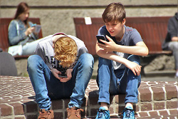 Auf dem Bild sind zwei, auf einer Stufe sitzende Jungen zu sehen.