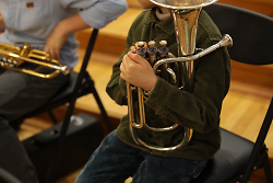 Auf dem Bild sind Kinder zu sehen, die auf Instrumenten musizieren.